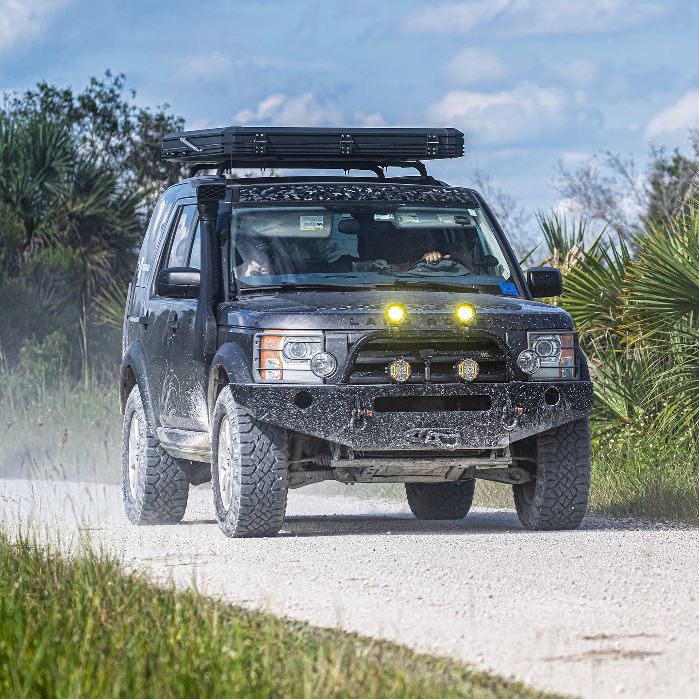 Overland rig kicking up dust on a limestone road