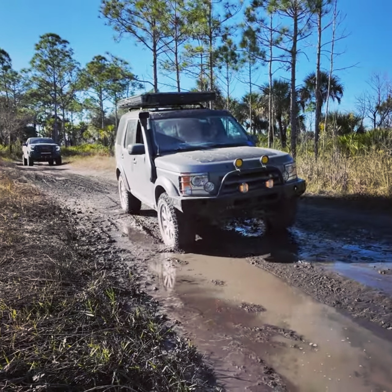 4x4 working through a deep muddy puddle on a trail