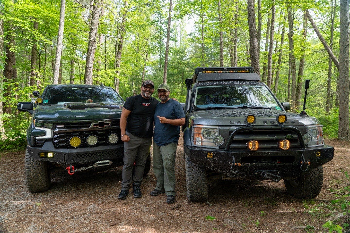 Overlanders talking beside their rigs at camp