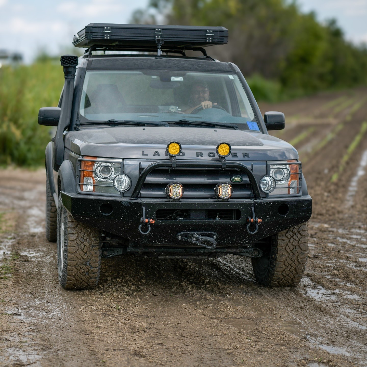 Stock-looking SUV on a muddy forest track