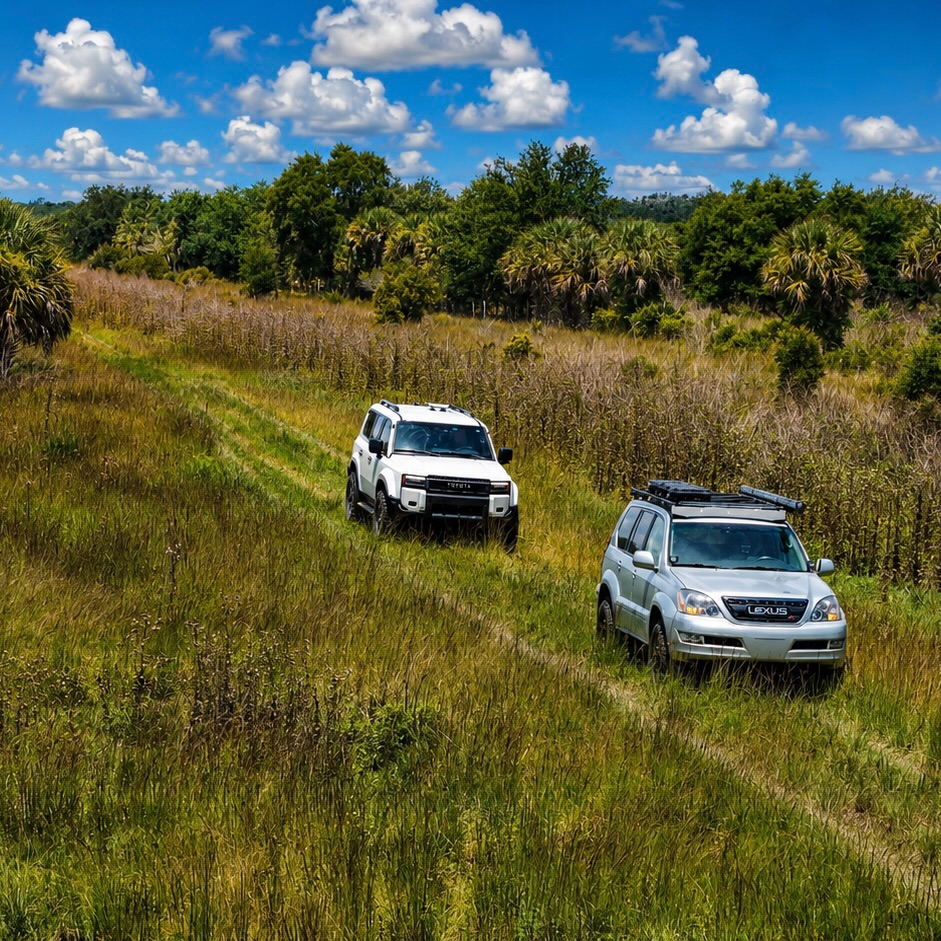 Two rigs pushing through tall summer grass